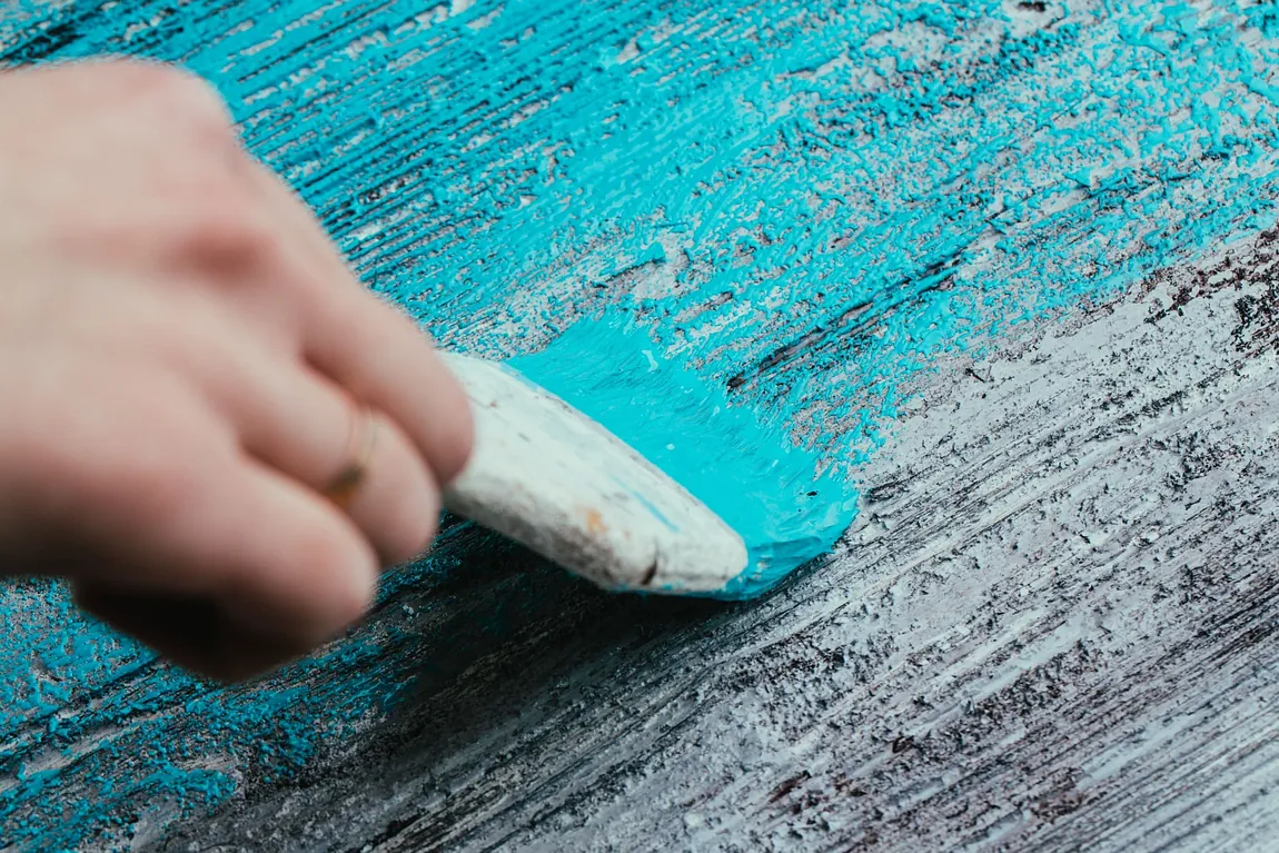 Mujer pinta tablero de azul celeste con brocha